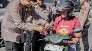 Kapolres SBD saat membagikan bendera kepada para pengendara jelang HUT RI ke 80.(Dokumen Humas Polres SBD)